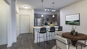 The hendrix apartments an open kitchen and dining area with a table and chairs
